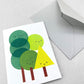 Mini greetings card with an image of a group of trees with smily faces. By Scout Editions.