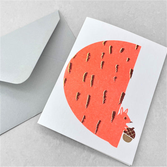 Mini greetings card with an image of an orange squirrel eating an acorn. By Scout Editions.