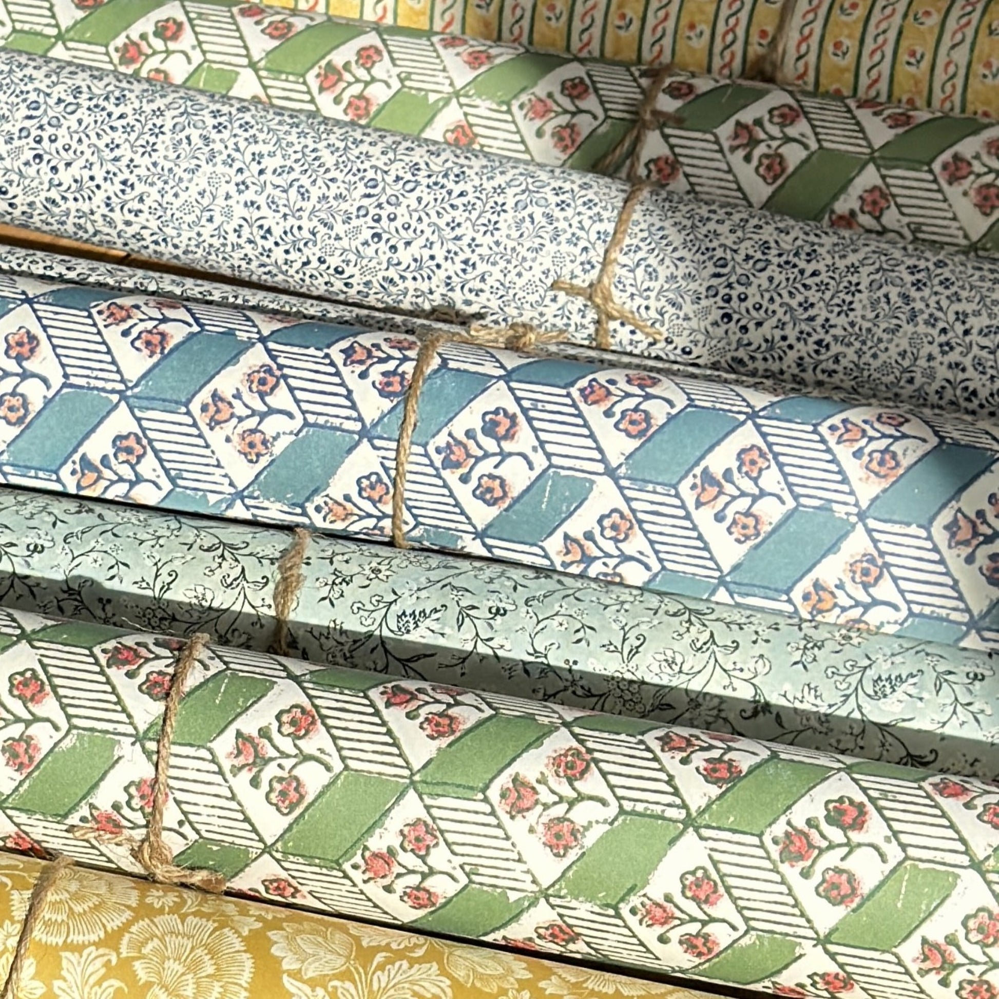 italian florentine wrapping papers rolled, various designs in colours of green, blue and yellow 