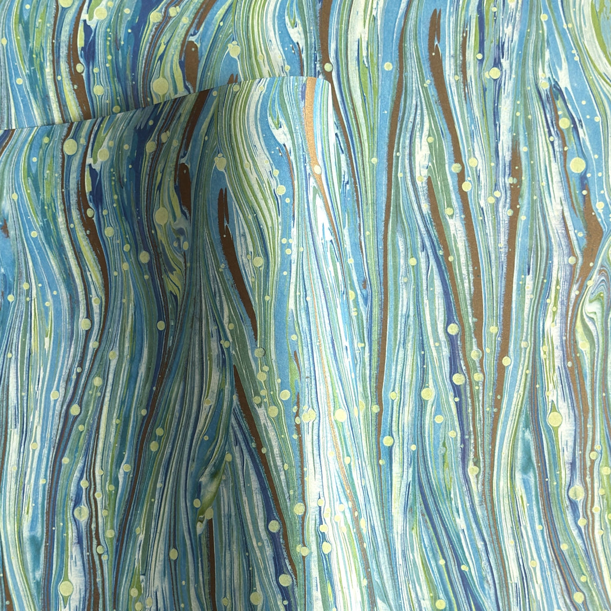 a sheet of Italian printed marbled wrapping paper by Tassotti with a marble pattern in aqua, blue, green, white an gold