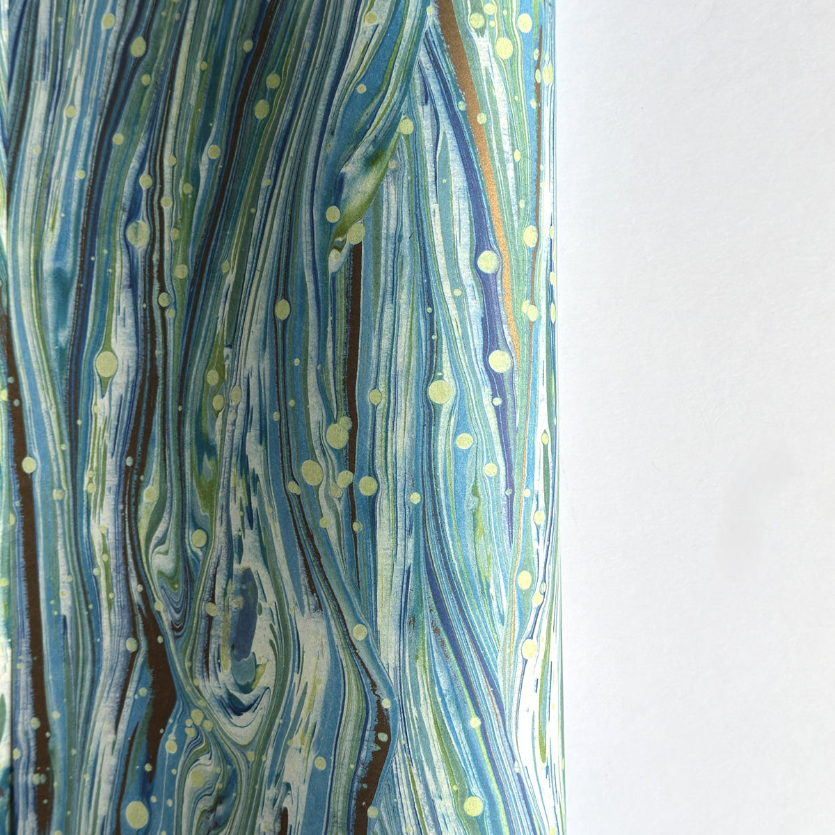 a sheet of Italian printed marbled wrapping paper by Tassotti with a marble pattern in aqua, blue, green, white an gold