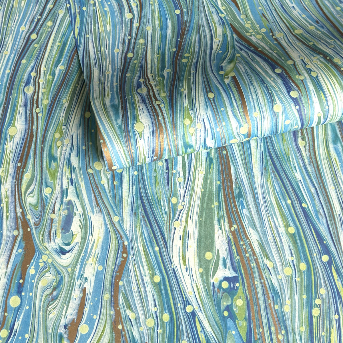 a sheet of Italian printed marbled wrapping paper by Tassotti with a marble pattern in aqua, blue, green, white an gold