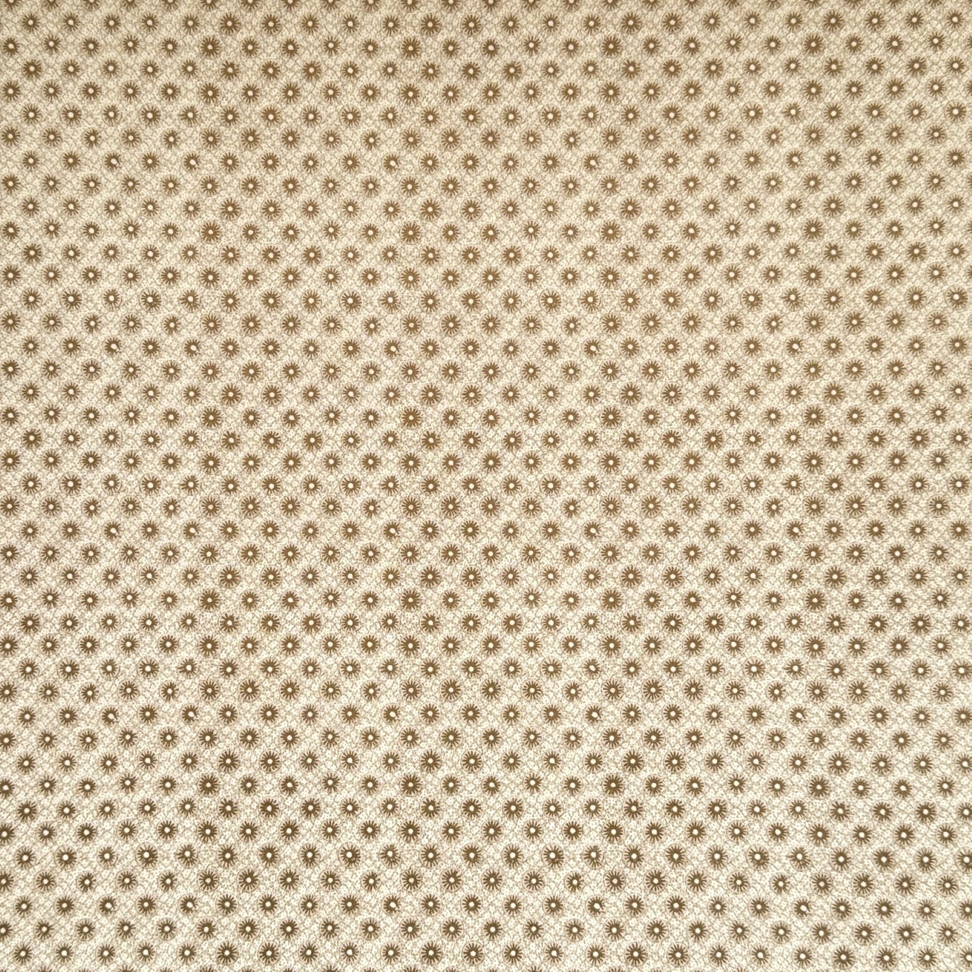 a sheet of italian wrapping paper with gold snowflakes on a cream backdrop. 