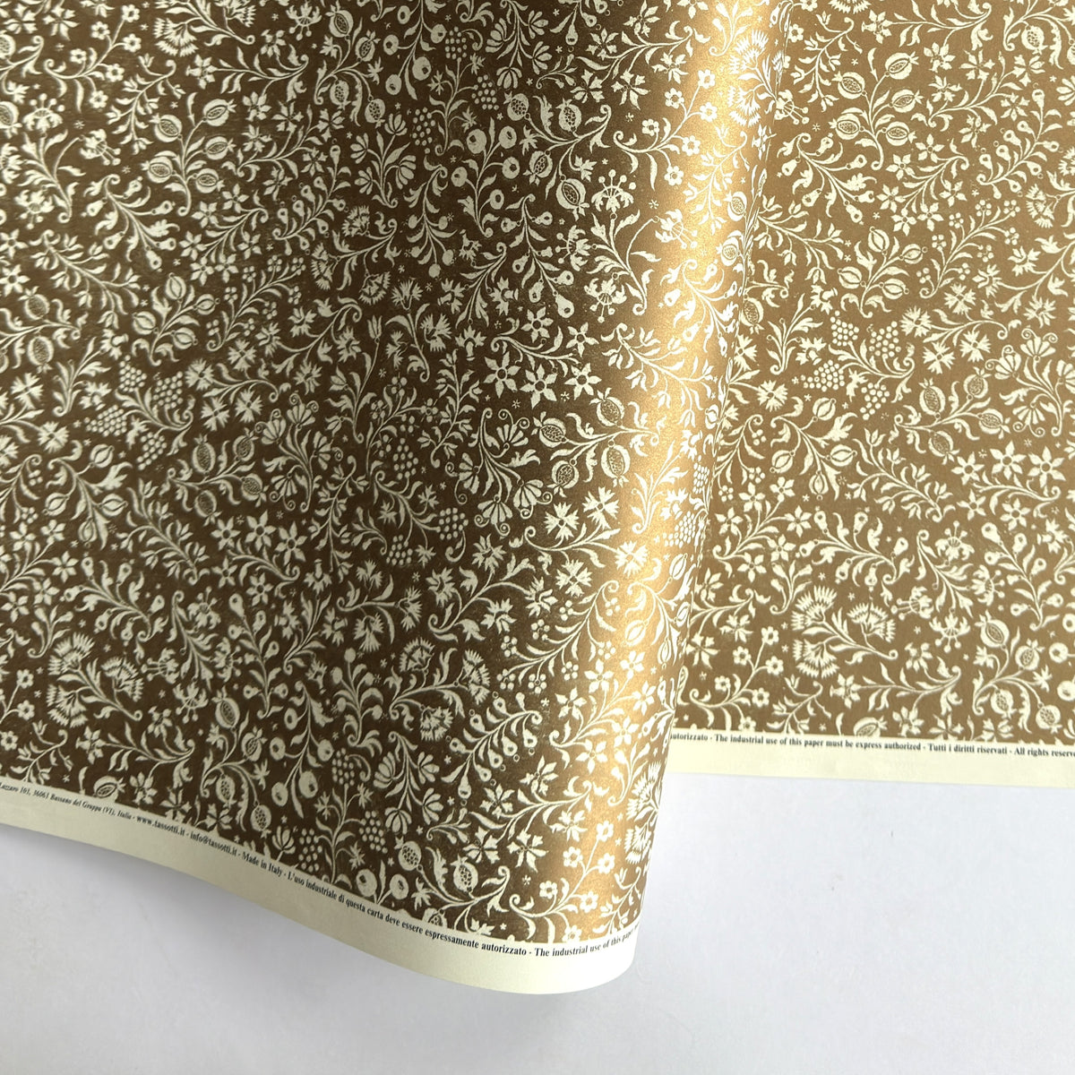 a sheet of Italian wrapping paper by Tassotti, the design is from the Remondini archives and is a small scale botanical block print on an antique gold ground