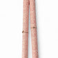 a sheet of italian wrapping paper with a small delicate floral pattern in red on white background. Pictured rolled