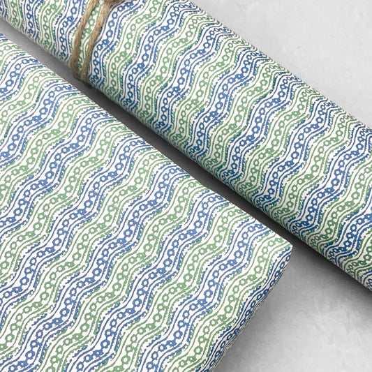 italian patterned wrapping paper "Carta Varese" by Grafiche Tassotti. Pattern of small wavy lines in blue and green on a cream backdrop.