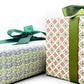 italian patterned wrapping paper "Carta Varese" by Grafiche Tassotti. Pattern of small wavy lines in blue and green on a cream backdrop.  Pictured wrapped up with a green bow alongside another present.