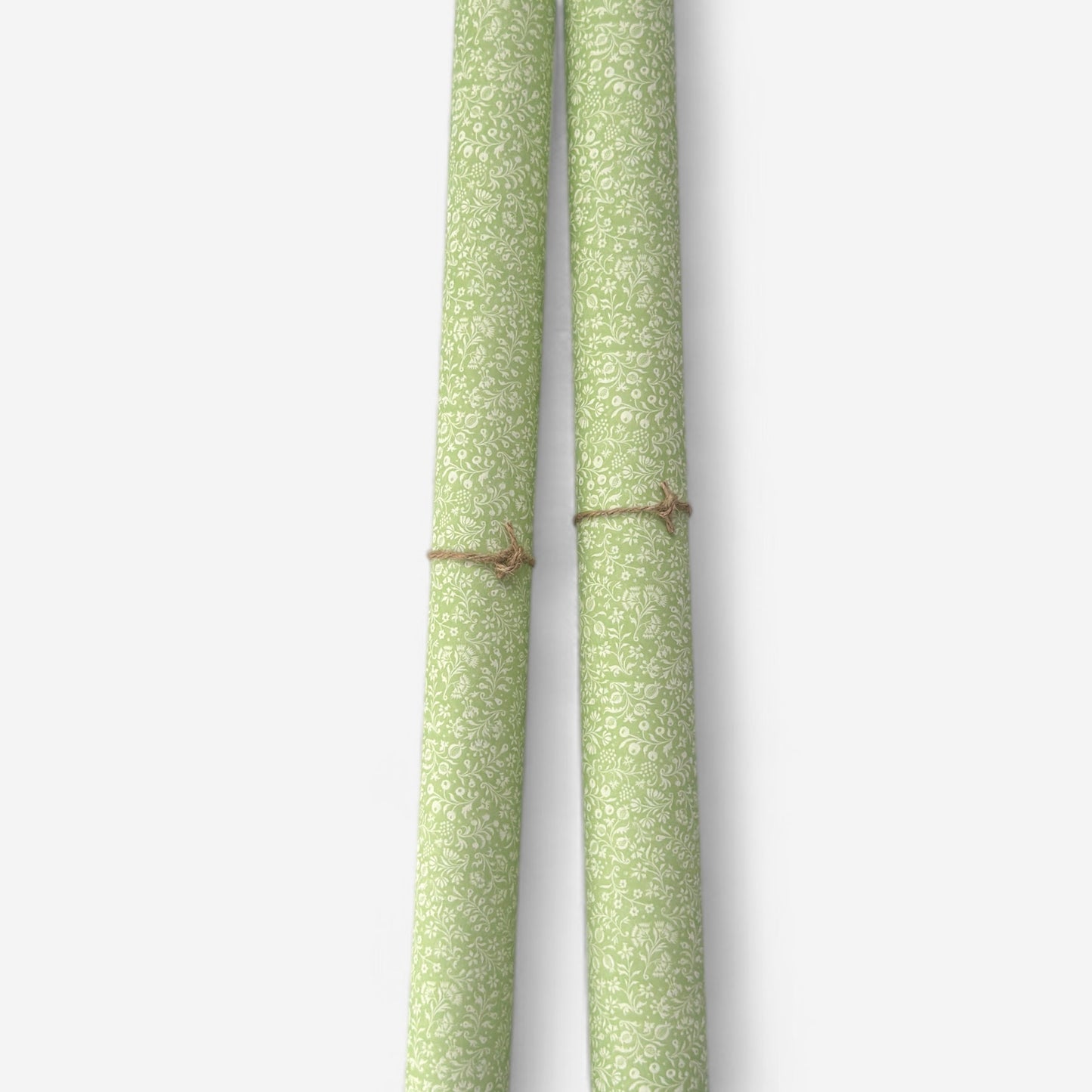 a sheet of italian wrapping paper with a delicate small floral design in light green and white. Pictured rolled