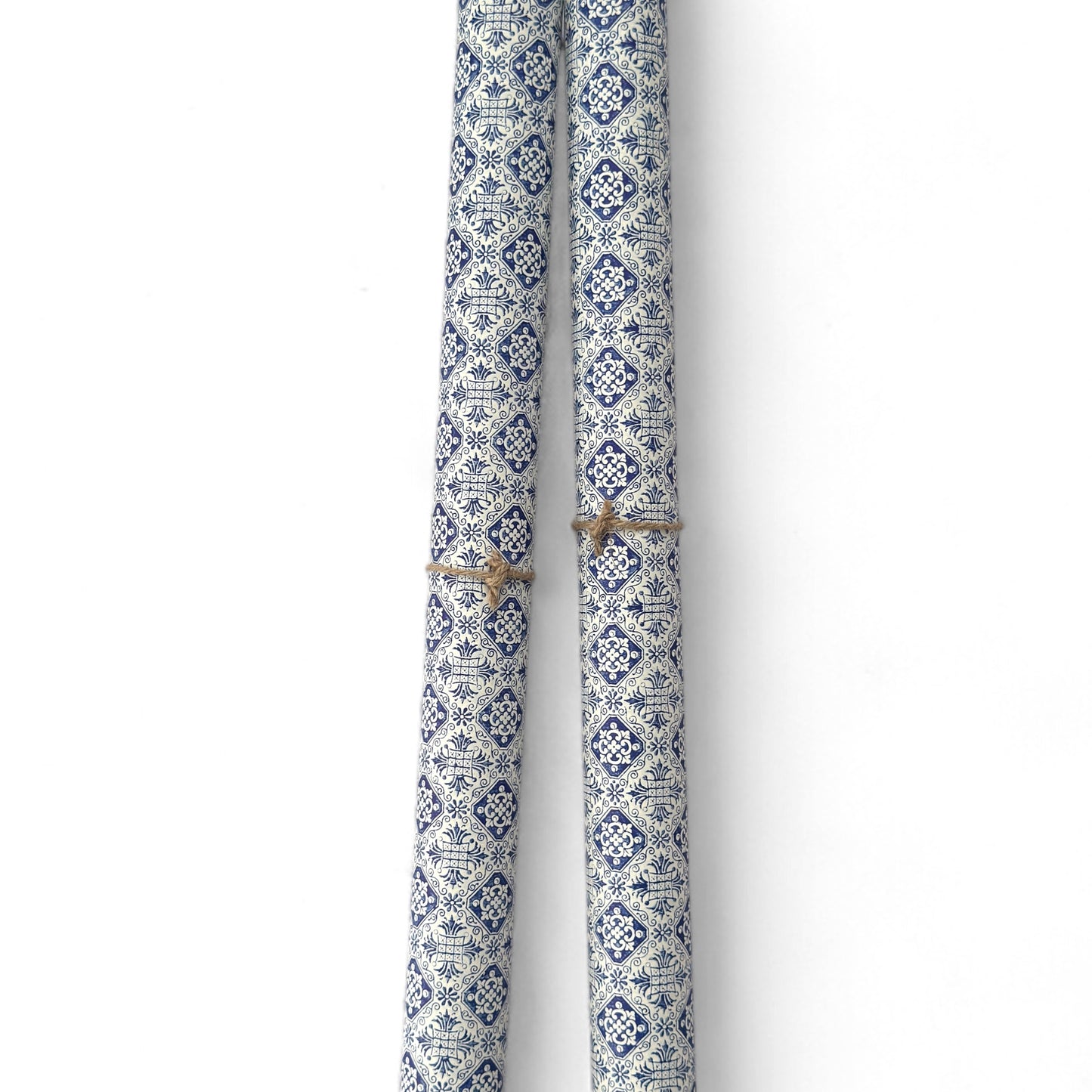 a sheet of italian wrapping paper with a blue block print repeat stamp pattern on white. Pictured rolled