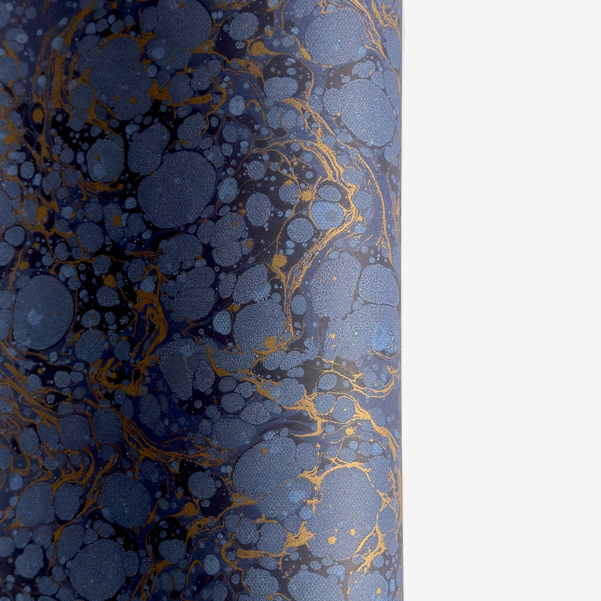 a sheet of Italian wrapping paper by Tassotti with a marbled pattern in dark and light blue with gold veins