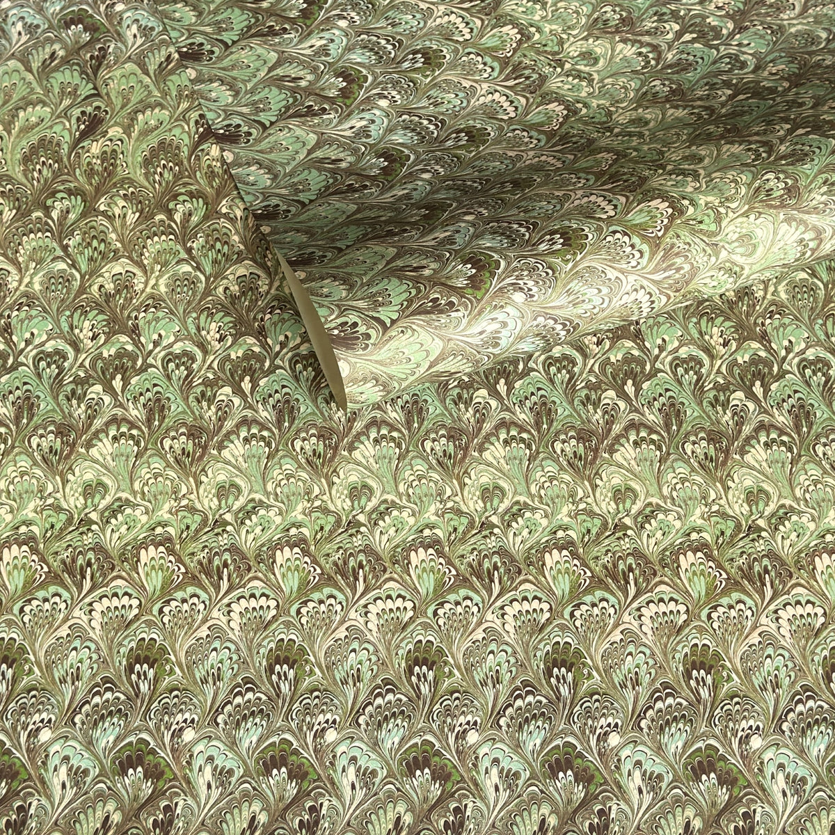 a sheet of Italian printed marbled paper by Tassotti with a marbled design in tones of green and cream