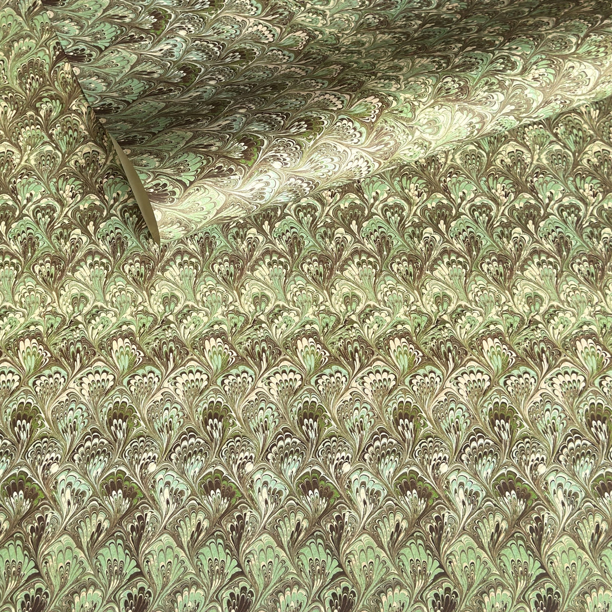 a sheet of Italian printed marbled paper by Tassotti with a marbled design in tones of green and cream