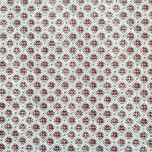 a sheet of italian wrapping paper with a little red flower in a diamond grid design in green