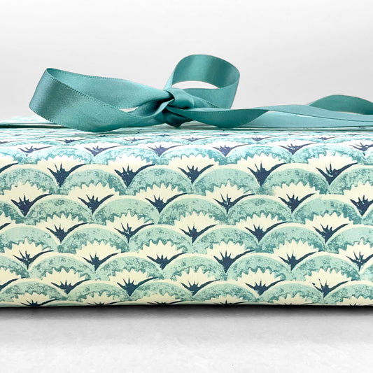 italian Remondini patterned wrapping paper by Tassotti.. All over repeat pattern of block printed style waves in aqua, dark blue on white background.