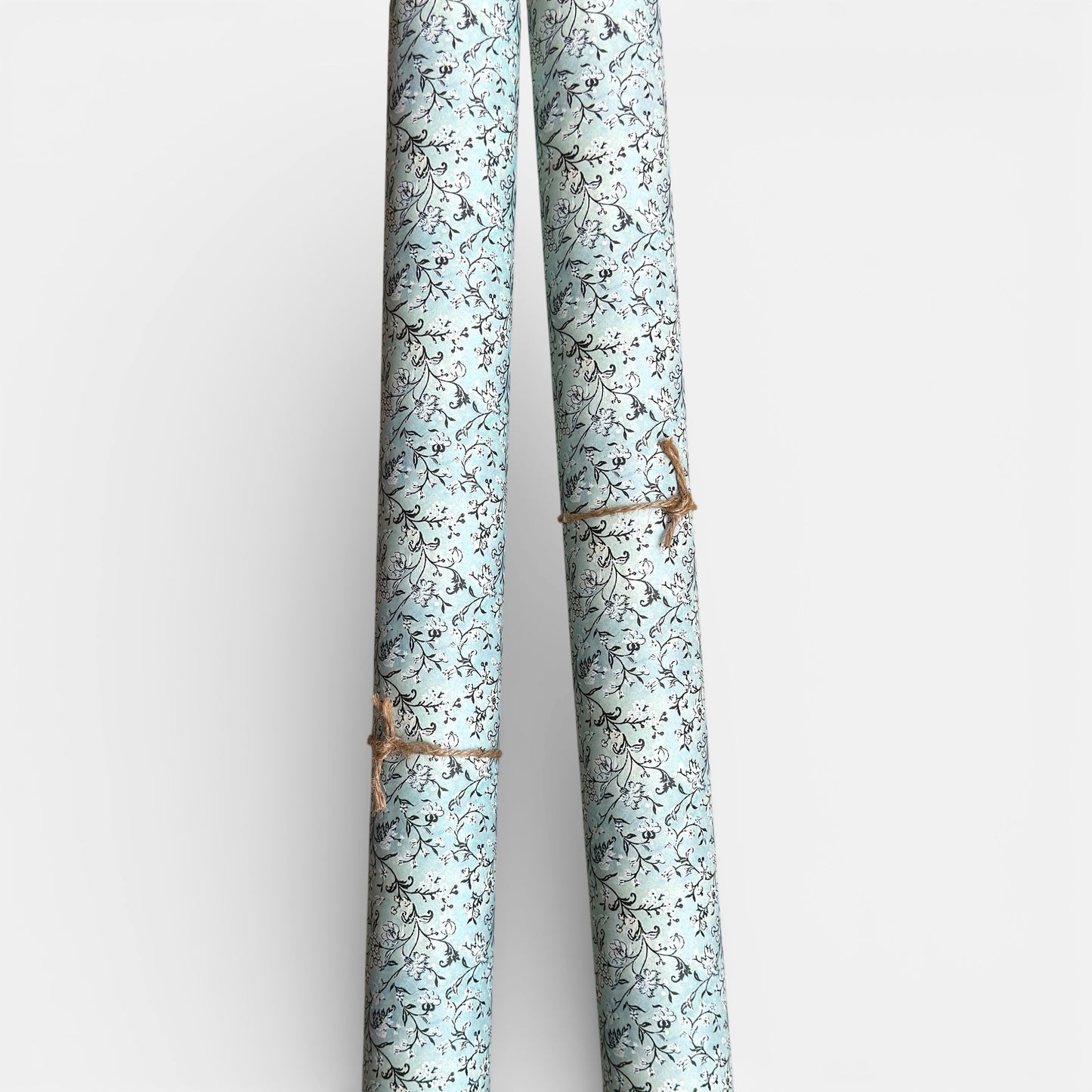 floral italian florentine wrapping paper with a white repeat floral on a mustard background. Pictured rolled