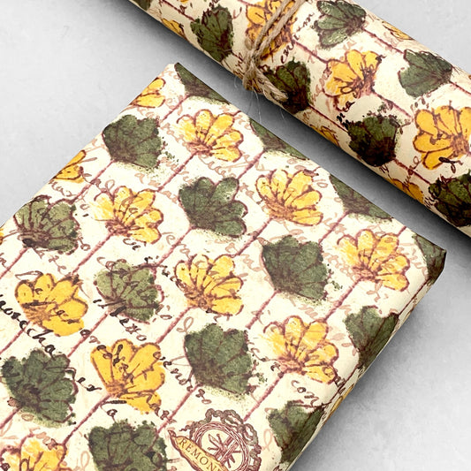 italian Remondini patterned wrapping paper by Tassotti.  Repeat floral pattern with yellow and green flowers on a beige background with script writing