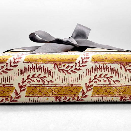 italian Remondini patterned wrapping paper by Tassotti. Mustard stripes with burgundy block printed garland on cream backdrop
