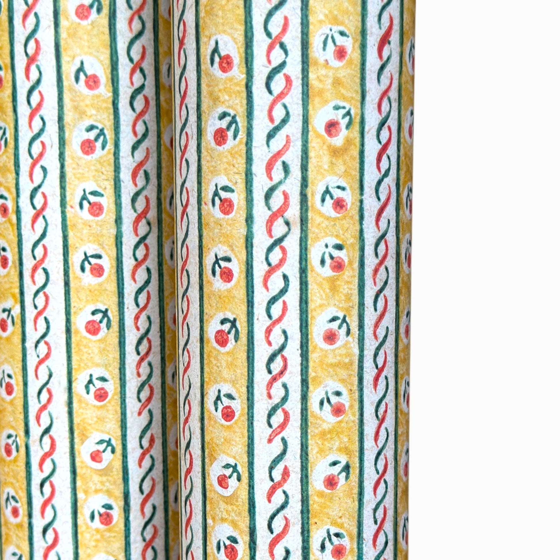 a sheet of florentine italian wrapping paper with a striped design in yellow, green, red and white with a little flower block print between the stripes