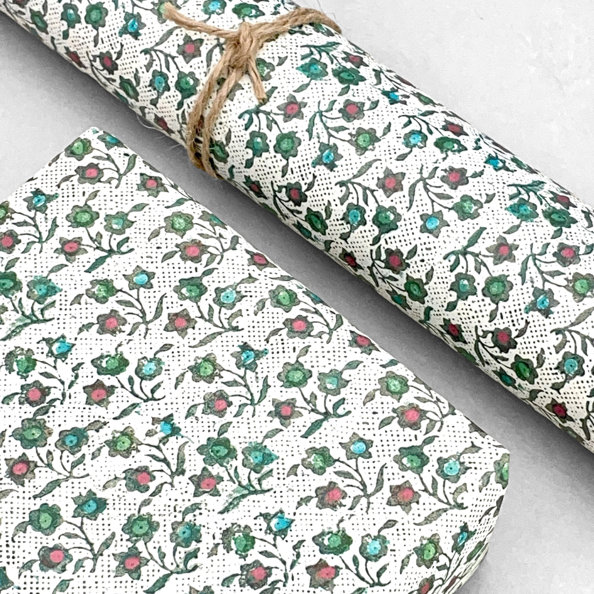 italian Remondini patterned wrapping paper by Tassotti.  Little floral repeat pattern of block print style flowers in blue, red and green on a white background