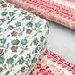 italian Remondini patterned wrapping paper by Tassotti. Little floral repeat pattern of block print style flowers in blue, red and green on a white background. Close up
