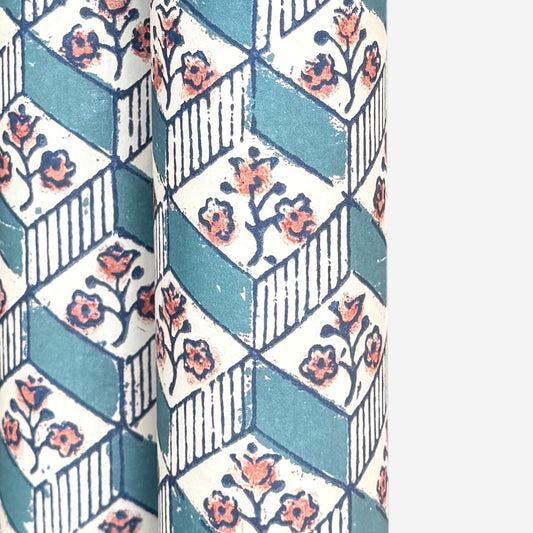 italian remondini florentine wrapping paper with a geometric rombi pattern in blue with a block print flower in pink on a white background