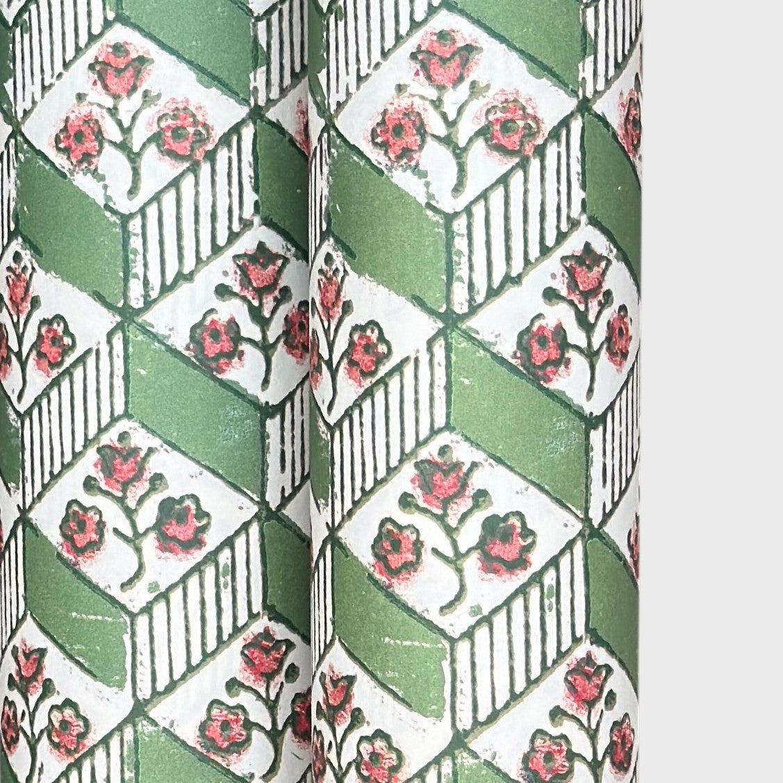 italian florentine wrapping paper with a geometric rombi design in green on white with a little block printed flower