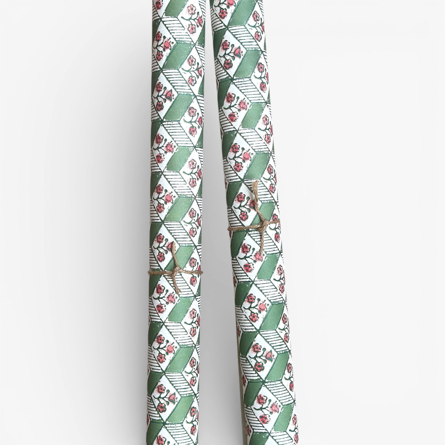 italian florentine wrapping paper with a geometric rombi design in green on white with a little block printed flower. Pictured rolled