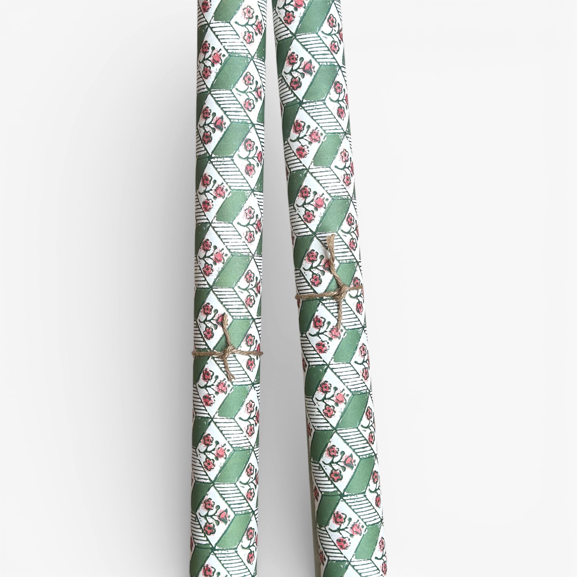italian florentine wrapping paper with a geometric rombi design in green on white with a little block printed flower. Pictured rolled