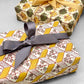 italian Remondini patterned wrapping paper by Tassotti. Block printed rhombus pattern with little flowers in yellow, white and green. Wrapped as a present
