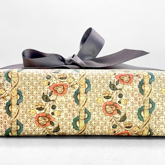 Remondini Italian patterned wrapping paper by Tassotti, A detailed trellis design with flowers in taupe, rose and aqua colours. Pictured wrapped with a grey ribbon bow. Close up