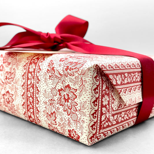 italian Remondini patterned wrapping paper by Tassotti.  A delicate broccate pattern in red on cream.  Pictured as a present with a red ribbon bow