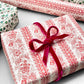 italian Remondini patterned wrapping paper by Tassotti. A delicate broccate pattern in red on cream. Pictured as a present with a pink velvet ribbon bow