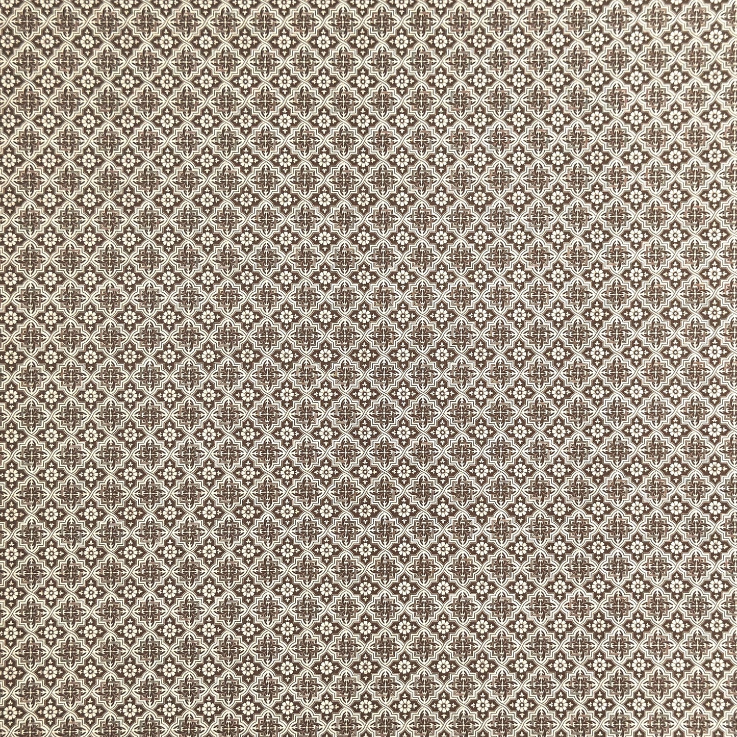 a sheet of italian wrapping paper with a small repeat geometric - floral pattern in brown and white