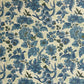 a sheet of wrapping paper by The Kensington Paperie with a large chintz floral in teal blue, with green foliage and a speckled light green ground 