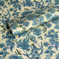 a sheet of wrapping paper by The Kensington Paperie with a large chintz floral in teal blue, with green foliage and a speckled light green ground 