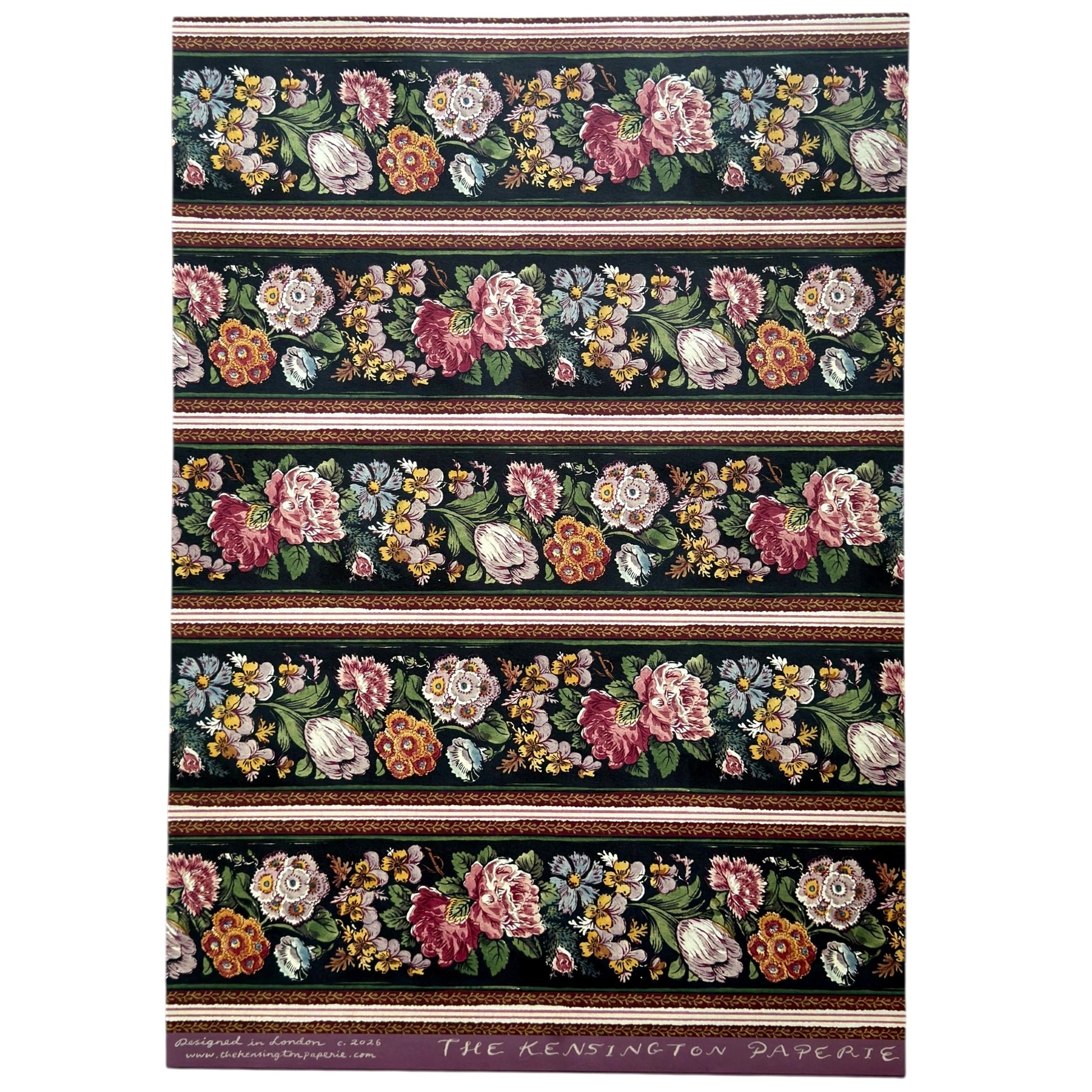 A sheet of wrapping paper, showing a detailed pattern of pink, white, and yellow flowers with green leaves on a black, bordered by horizontal stripes in pink, white, and brown.