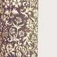 A sheet of dark aubergine wrapping paper with a dense cream floral and vine pattern
