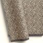 A sheet of dark aubergine wrapping paper with a dense cream floral and vine pattern, shown partially unrolled on a white background. 