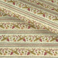 A close-up of patterned wrapping paper with horizontal stripes and a repeating floral vine motif in muted green, pink, and brown on an off-white background. 