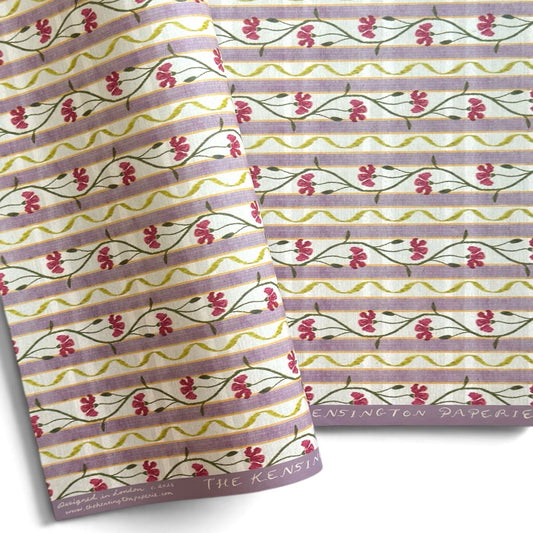 A close-up of patterned paper with horizontal lavender stripes, small pink flowers, and green stems. 