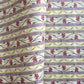 A close-up of a patterned wrapping paper featuring horizontal lavender and cream stripes with pink flowers, green stems, and olive-green wavy lines.