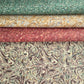 a printed marbled wrapping paper sheet with swirling brown, beige, muted green, and small yellow accents. By The Kensington Paperie brand. Pictured alongside versions in red, yellow and green
