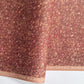 a marbled patterned wrapping paper with swirling abstract swirls in reddish brown, rust, beige, and muted gold tones.