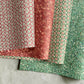 four sheets of wrapping paper by The Kensington Paperie brand. Tow are stamped block print designs and two are marbled designs. In soft reds and greens.