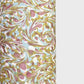 A close-up of a marbled patterned paper with swirling abstract swirls in muted gold, dusty pink, pale blue, and off-white, shown against a light gray background.