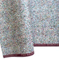 A close-up of patterned paper with an intricate swirling marbled design in white, blue, green, and burgundy.