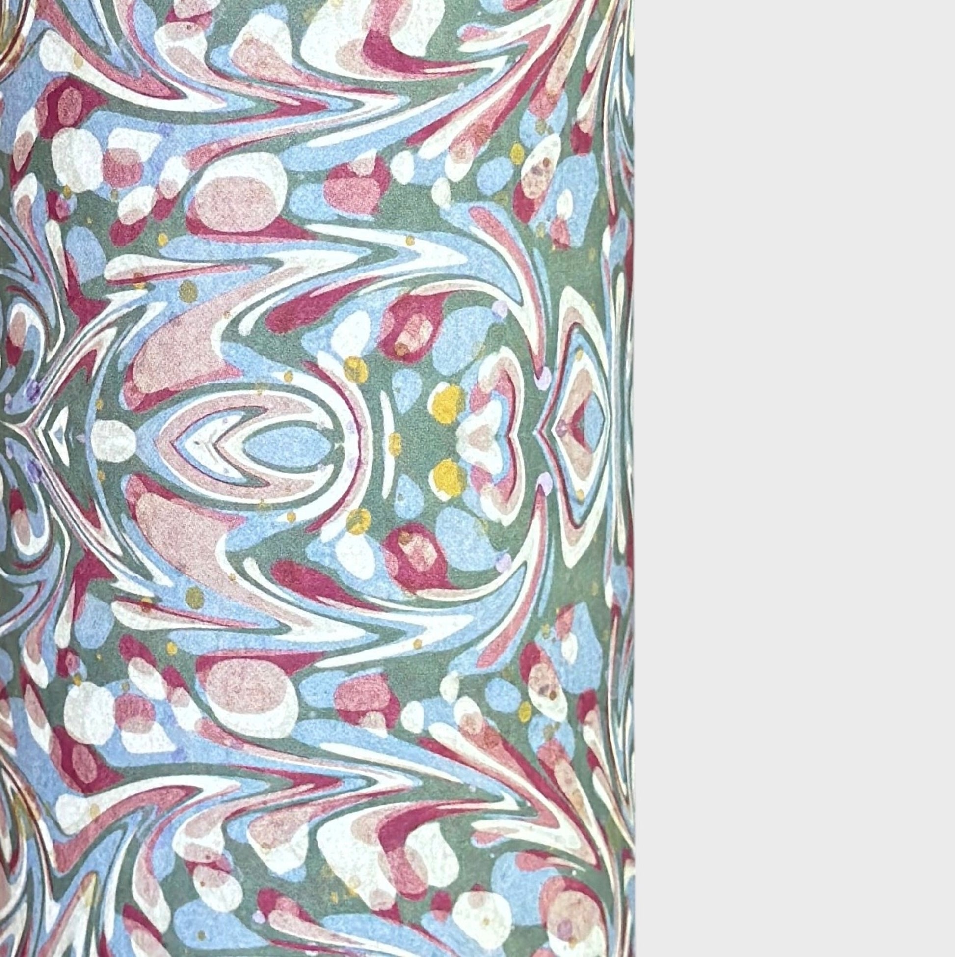 A close-up of patterned paper with an intricate swirling marbled design in white, blue, green, and burgundy.