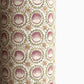 close up of a sheet of wrapping paper with a block printed design of rows of English steam puddings in pink