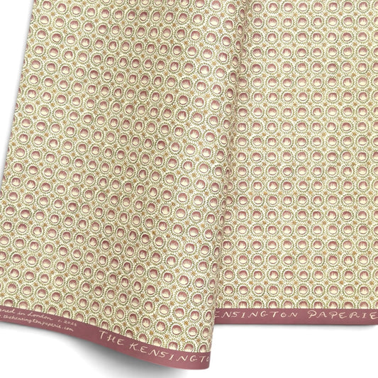  a sheet of wrapping paper with a block printed design of rows of English steam puddings in pink