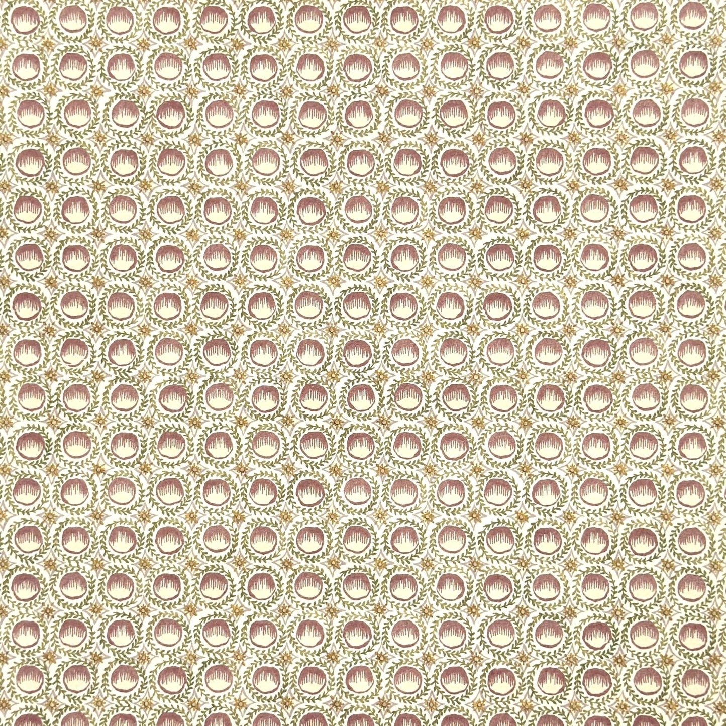 close up of a sheet of wrapping paper with a block printed design of rows of English steam puddings in pink